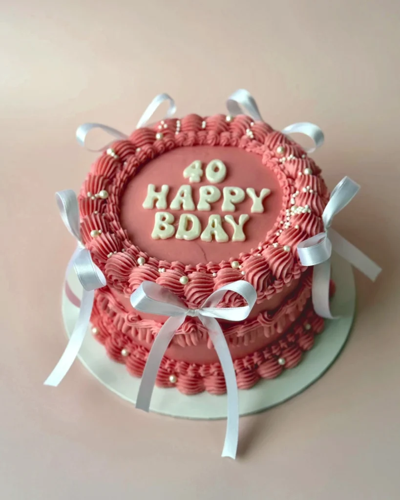 Roze vintage verjaardagstaart met witte strikjes